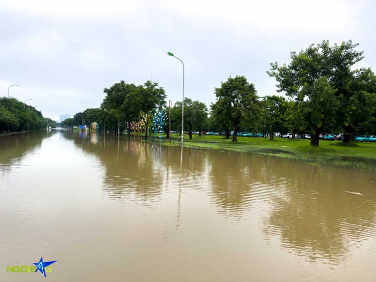 Trước Vincom Mega Mall Smart City ngập sâu, nhiều xe máy phải leo lên đường cao tốc để tránh.