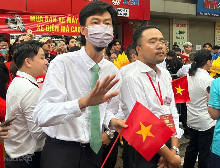 Rapper mặc trang phục phong cách công sở với áo sơmi, quần tây, cà vạt xanh lá cây.