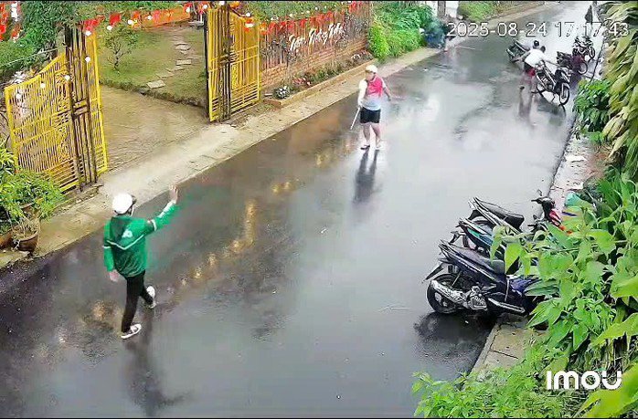 Một người trong nhóm hành hung cầm vật giống gậy sắt ngăn cản người dân