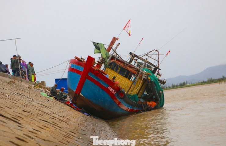 Con thuyền của gia đình ông Việt bị sóng đánh dạt lên kè.