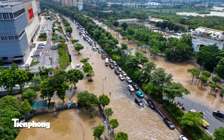 Đoạn ngập kéo dài hàng trăm mét trước khu đô thị lớn và trung tâm thương mại, nơi có lưu lượng giao thông cao.