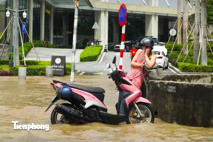 Một du khách nước ngoài cũng gặp sự cố chết máy khi đi qua đoạn ngập trên đường Võ Chí Công, phải dắt xe lên vỉa hè.