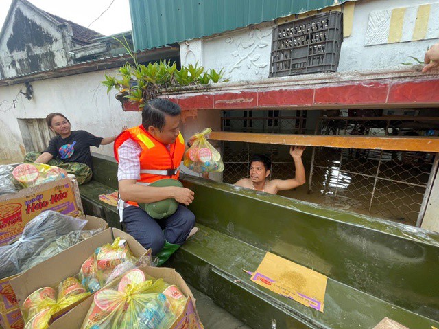Ông Nguyễn Việt Hùng, Bí thư Đảng ủy phường Hàm Rồng tiếp tế lương thực cho các hộ dân bị ngập lụt.