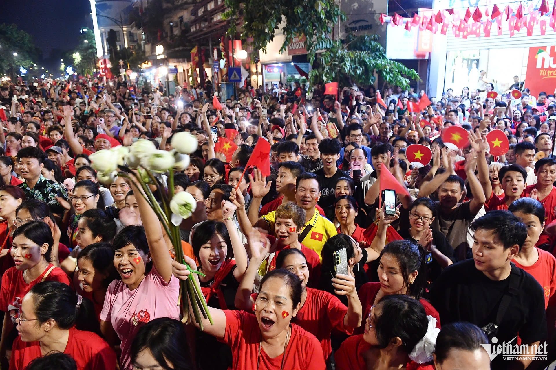 Khi tiếng nhạc Quốc ca vang lên, nhiều người dân trên các tuyến phố đứng dậy chào cờ, hát vang bài Quốc ca. Ảnh: Hoàng Hà