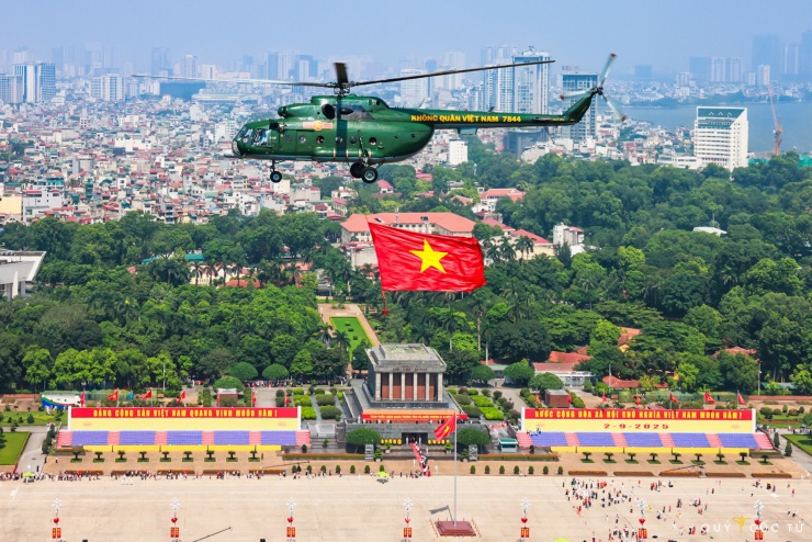 Trực thăng của Không quân Việt Nam treo cờ Tổ quốc biểu diễn bay trong buổi hợp luyện trên bầu trời quảng trường Ba Đình. Ảnh: Ngô Trần Hải An.