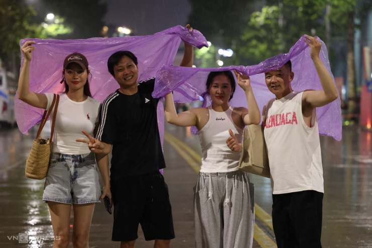 Các gia đình tạo dáng dưới trời mưa trên giao lộ Trần Phú - Hùng Vương. Ảnh: Quỳnh Trần