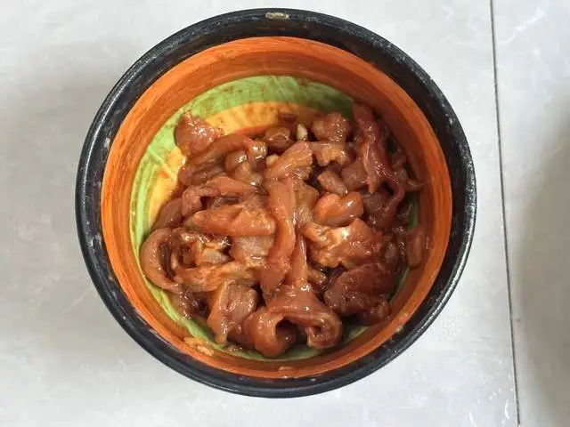 Thịt thăn rửa sạch, thái sợi nhỏ. Cho vào tô cùng nước tương, hắc xì dầu, tiêu, muối, dầu hào và nhiều bột ngô. Dùng tay trộn kỹ đến khi thịt phủ đều lớp bột hơi sệt. Cuối cùng cho thêm chút dầu ăn, trộn đều để giữ độ ẩm. Đậy kín, ướp khoảng 15 phút.