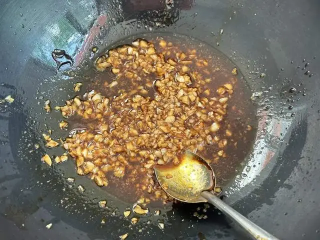 Phi thơm tỏi băm, sau đó cho vào nước tương, giấm, muối, dầu hào và bột ớt ngọt, khuấy đều. Ai thích cay có thể thêm ớt đỏ băm.