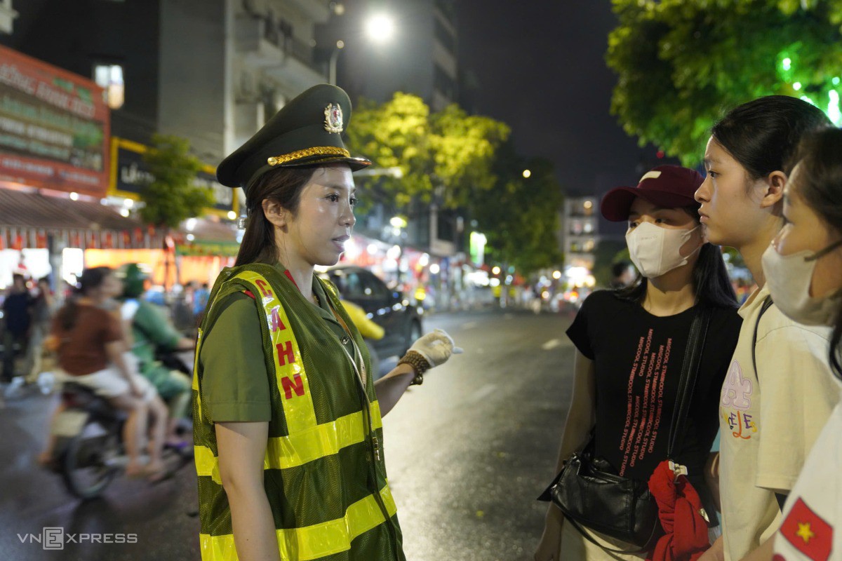 Đại úy Nguyễn Thị Thu, Công an TP Hà Nội hướng dẫn người dân di chuyển trong khu vực cấm phương tiện. Ảnh: Nguyễn Đông