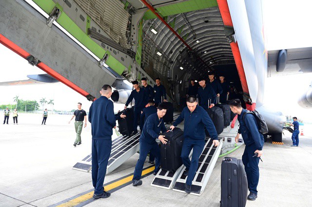 Các quân nhân di chuyển tư trang từ máy bay xuống.