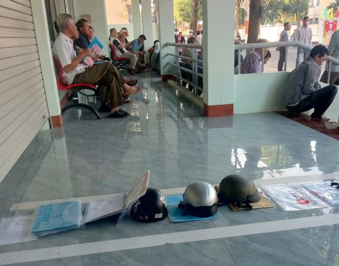 Người dân "xếp hàng" bằng mũ bảo hiểm, tài liệu chờ làm thủ tục hành chính