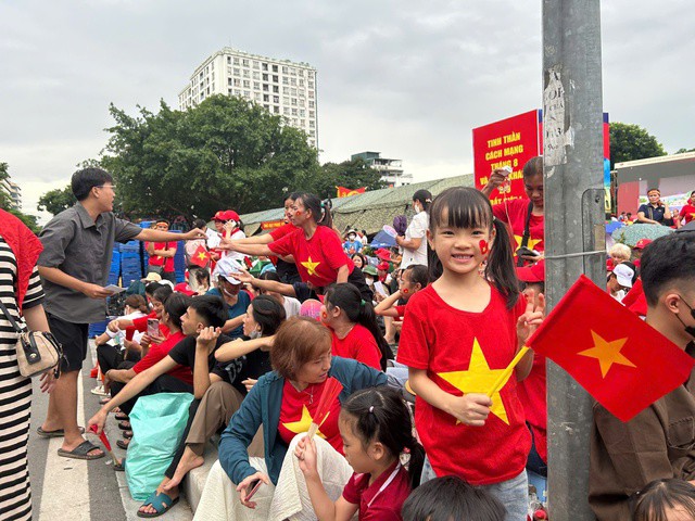 Một em bé háo hức chờ xem tổng duyệt diễu binh, diễu hành