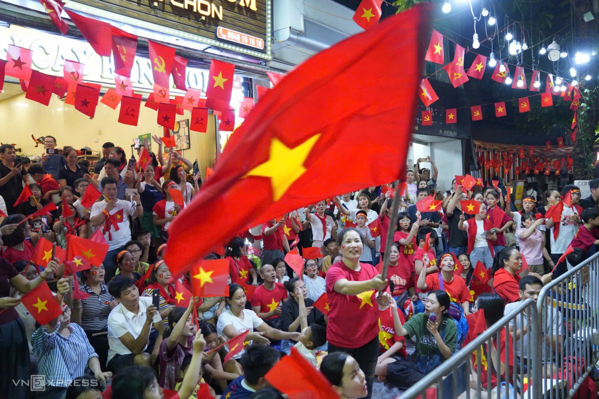 Người dân vừa hát vừa vẫy cờ. Ảnh: Nguyễn Đông