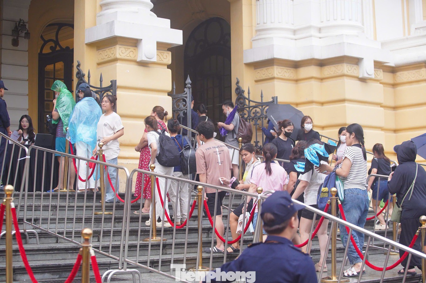 Một số người không kịp lấy ô, áo mưa phải đội mưa để nhận vé xem concert.