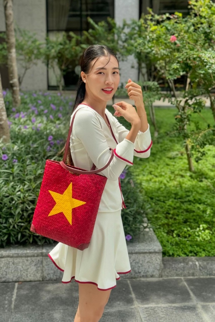 Á hậu Hoàng Oanh xuống phố trong set váy áo nữ tính và đeo túi cói mô phỏng quốc kỳ.