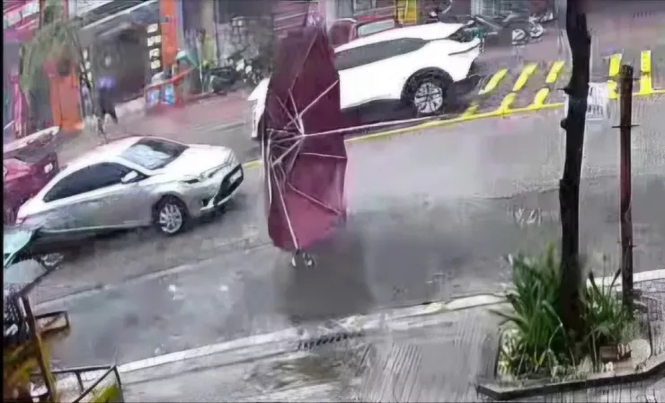 Gió lớn đã giật chiếc ô bên trong nhà bay ra ngoài đường, khiến một ô tô hư hỏng. Ảnh: MINH TRƯỜNG.