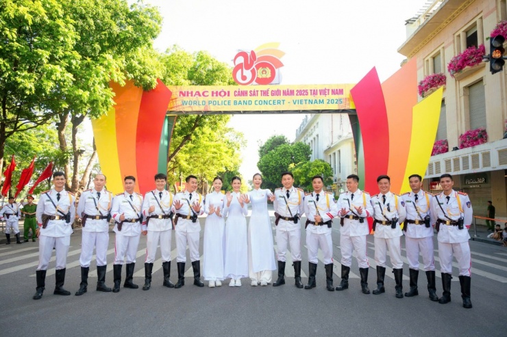 Các người mẫu chụp ảnh kỷ niệm cùng chiến sĩ tại một sự kiện trên đường phố.