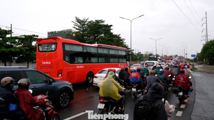 Mưa kéo dài suốt nhiều giờ, đường Lê Khả Phiêu (quốc lộ 1) đoạn từ phường An Lạc đến cầu Bình Điền 1, xe nối dài, di chuyển chậm. Trong ảnh: Dòng phương tiện di chuyển lên cầu Bình Điền 1.
