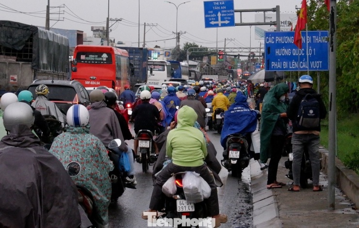 Mưa dần nặng hạt, nhiều người phải dừng ven đường để mặc áo mưa.