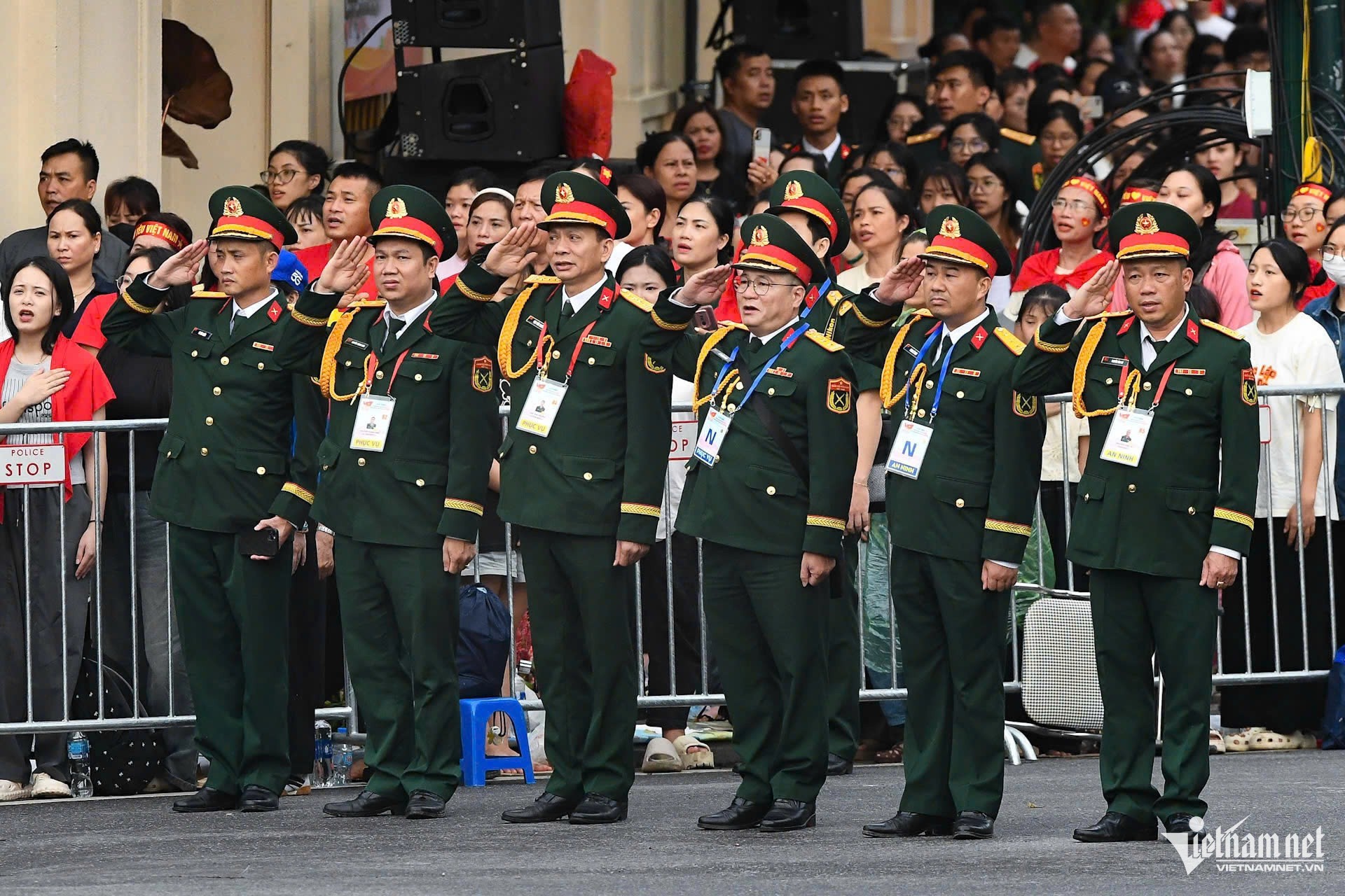 Lực lượng chức năng cùng người dân đứng nghiêm chào cờ tại khu vực Tràng Tiền, Nhà Hát Lớn. Ảnh: Thạch Thảo