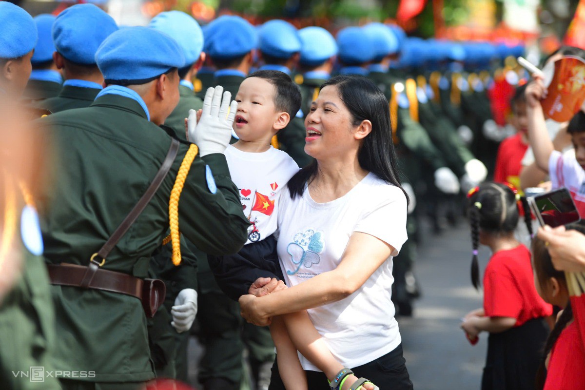 Các chiến sĩ cũng gửi các phần quà nhỏ cho các em bé hai bên đường. Ảnh: Thanh Tùng