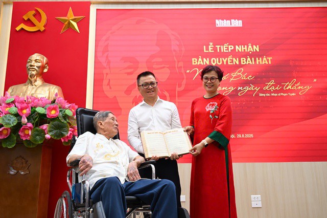 Chị Phạm Hồng Tuyến thay cha mình là nhạc sĩ Phạm Tuyên trao bài hát cho Tổng Biên tập báo Nhân Dân.