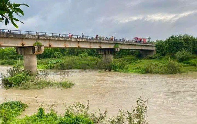 Người dân đứng trên bờ sông Dinh theo dõi tìm kiếm thi thể anh H. Ảnh: DT