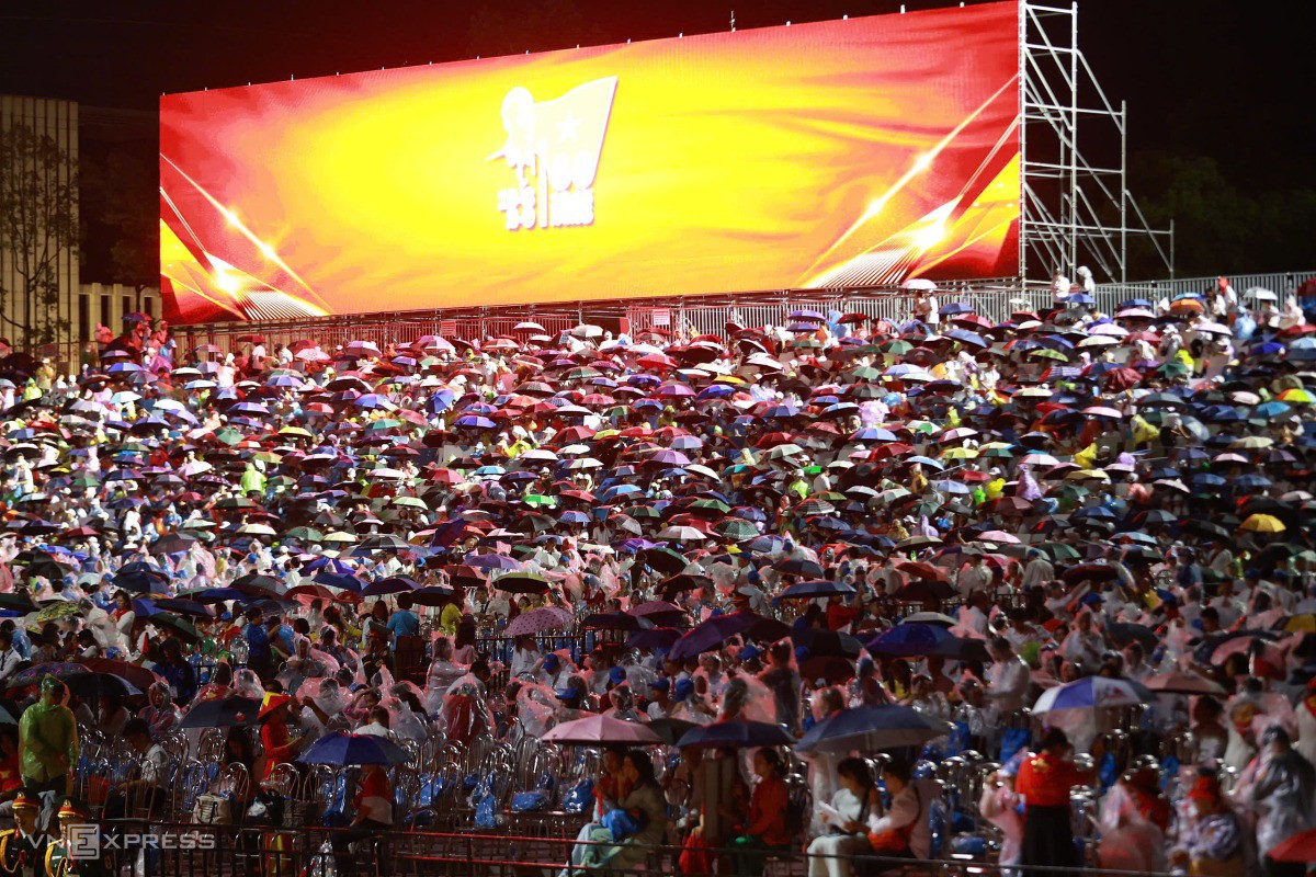 Trên khu vực đại biểu, khách mời che ô tránh mưa. Đức Đồng