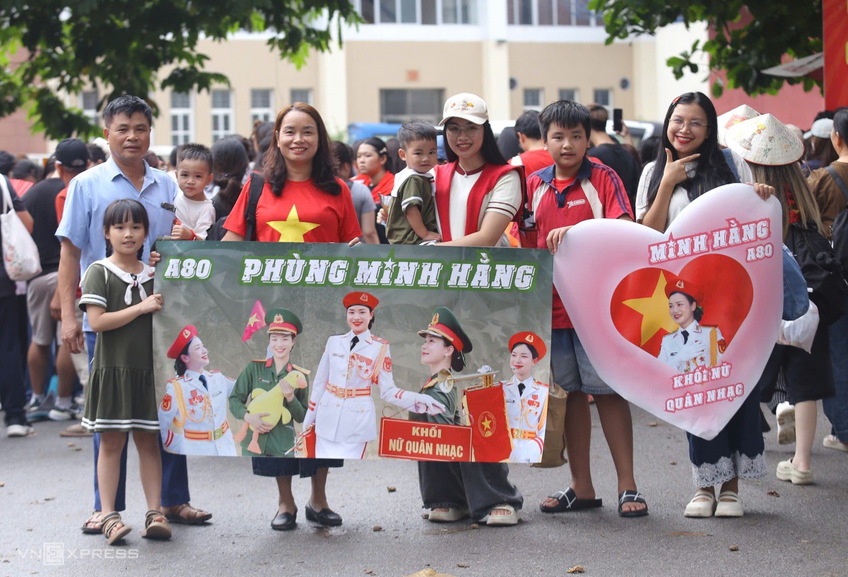 Gia đình chị Bùi Thị Huyền Điệp và tấm banner cổ động con gái. Ảnh: Thanh Hằng