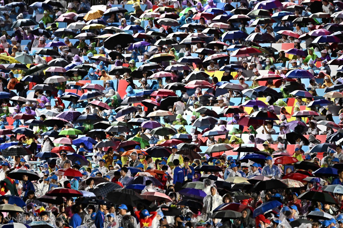 Đội xếp chữ trên khán đài đồng loạt giăng ô khi trời đổ mưa rào. Ảnh: Thanh Tùng