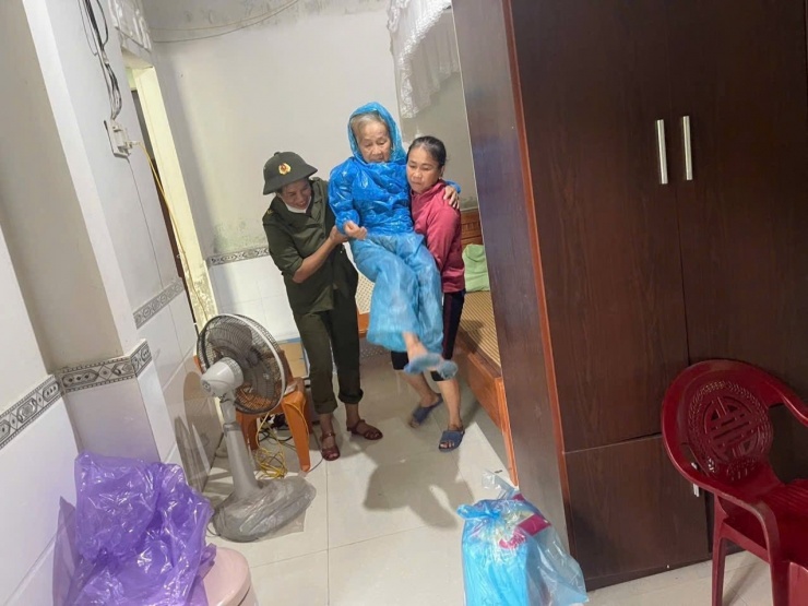 Lực lượng chức năng hỗ trợ di dời những hộ dân lên vị trí cao để đảm bảo an toàn.