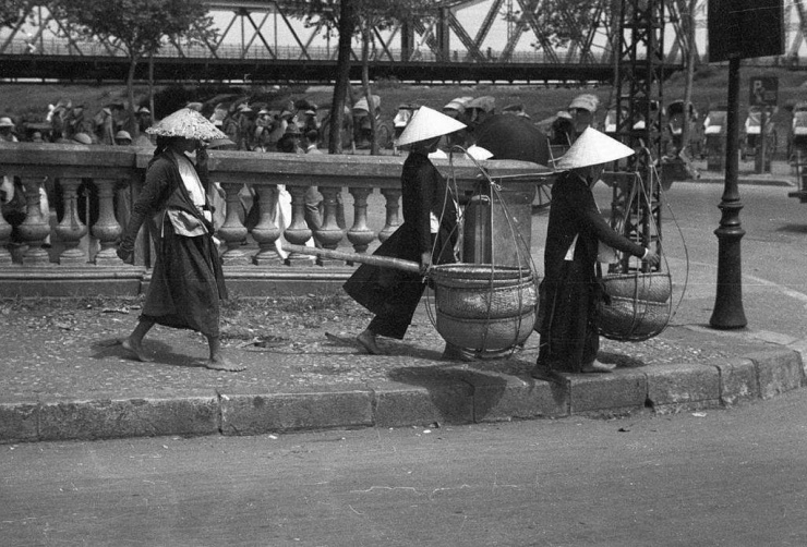 Những người phụ nữ mặc áo tứ thân đi qua cầu Long Biên, Hà Nội thập niên 1940. Ảnh: American Geographical Society Library