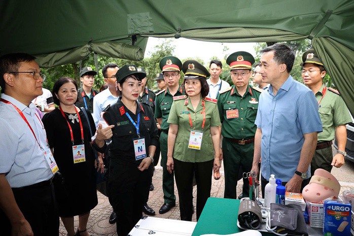 Lãnh đạo Bộ Y tế nghe báo cáo từ đại diện lán y tế của Cục Y tế Công an phục vụ sự kiện A80. Ảnh: Hoàng Nguyễn
