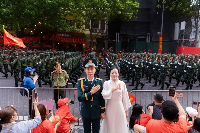 Cặp uyên ương ghi lại khoảnh khắc 'để đời' khi đoàn diễu binh đi qua.