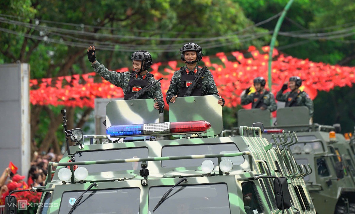 Chiến sĩ cảnh sát vẫy chào người dân. Ảnh: Nguyễn Đông