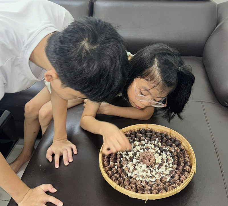 Các con chị An thích thú với món xôi trám thơm ngon mẹ vừa làm. (Ảnh: Bảo An)