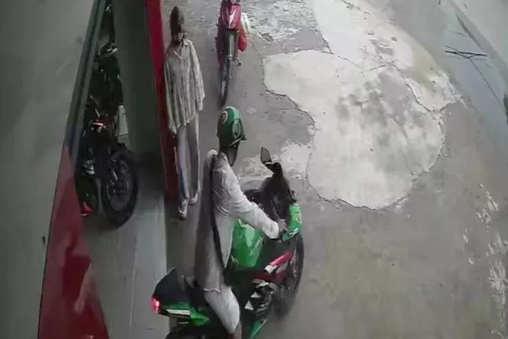 Hình ảnh Nguyễn Khanh để lại người yêu tại tiệm xe máy rồi lên xe chạy thử, chạy luôn. Ảnh cắt từ video clip