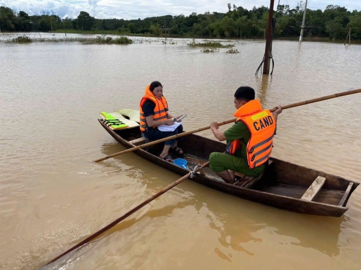 Cán bộ chèo thuyền vượt lũ đến vùng cô lập để chi trả tiền quà 2/9 cho người dân vùng bị cô lập.