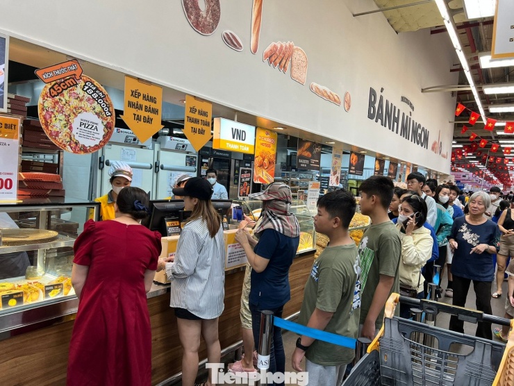 Khu thực phẩm chế biến, khách hàng
xếp hàng dài chờ thanh toán, sau đó lại tiếp tục rồng rắn để nhận
bánh. Tuy nhiên, ai cũng sẵn sàng xếp hàng chờ đợi vì sản phẩm ngon
rẻ, chất lượng như ý.