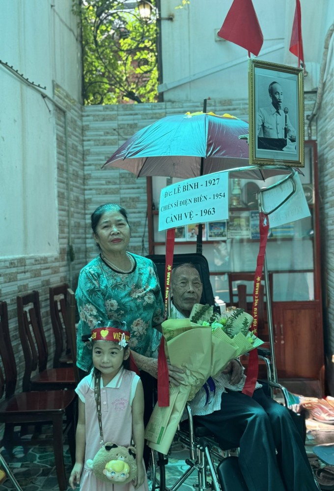 Ông Bình chụp ảnh lưu niệm cùng con cháu trên chiếc xe lăn được chuẩn bị sẵn tham gia diễu binh, tại nhà ở Thanh Trì, Hà Nội, hôm 31/8. Ảnh: Phạm Nga