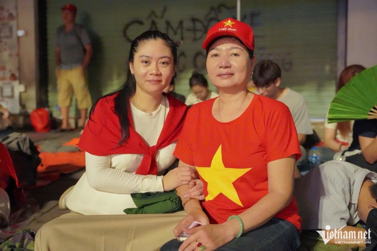 Bà Lê Thị Thoa mặc áo cờ đỏ sao vàng mong mỏi phút giây gặp con trai. Ảnh: Nguyễn Huy
