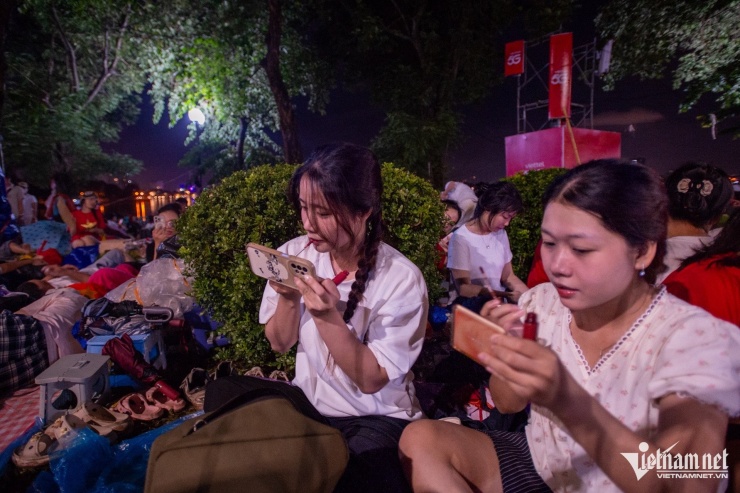Thuỳ Quyên và bạn thức dậy sớm dùng điện thoại soi gương để trang điểm. Ảnh: Thế Bằng