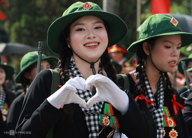 Nhiệt độ Hà Nội  hôm nay khoảng 28 độ C. Từ quảng trường Ba Đình tới cung thể thao Quần Ngựa hơn 2 km, các nữ du kích miền Nam ướt đẫm mồ hôi, nhưng vẫn tươi cười, tạo hình trái tim thể hiện tình cảm với người cổ  vũ. Ảnh: Đức Đồng