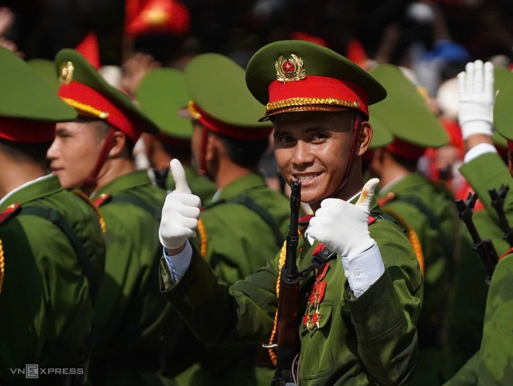 Một chiến sĩ cảnh sát trao cử chỉ thân thiện với cả rừng người trên phố Văn Cao. Ảnh: Lưu Quý 
