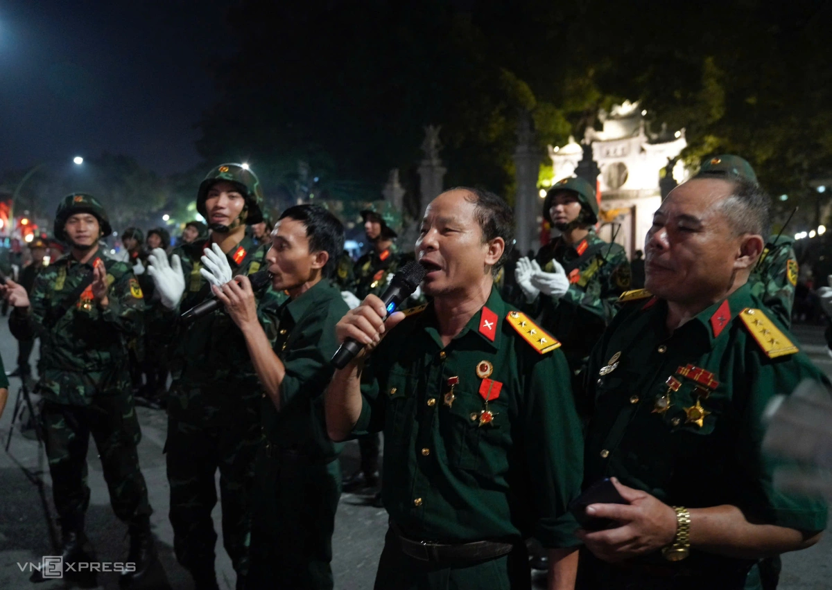 Các cựu chiến binh hát giao lưu với các chiến sĩ Pháo binh Tên lửa, trước đền Quán Thánh, đường Thanh Niên. Ảnh:&nbsp;Nguyễn Đông