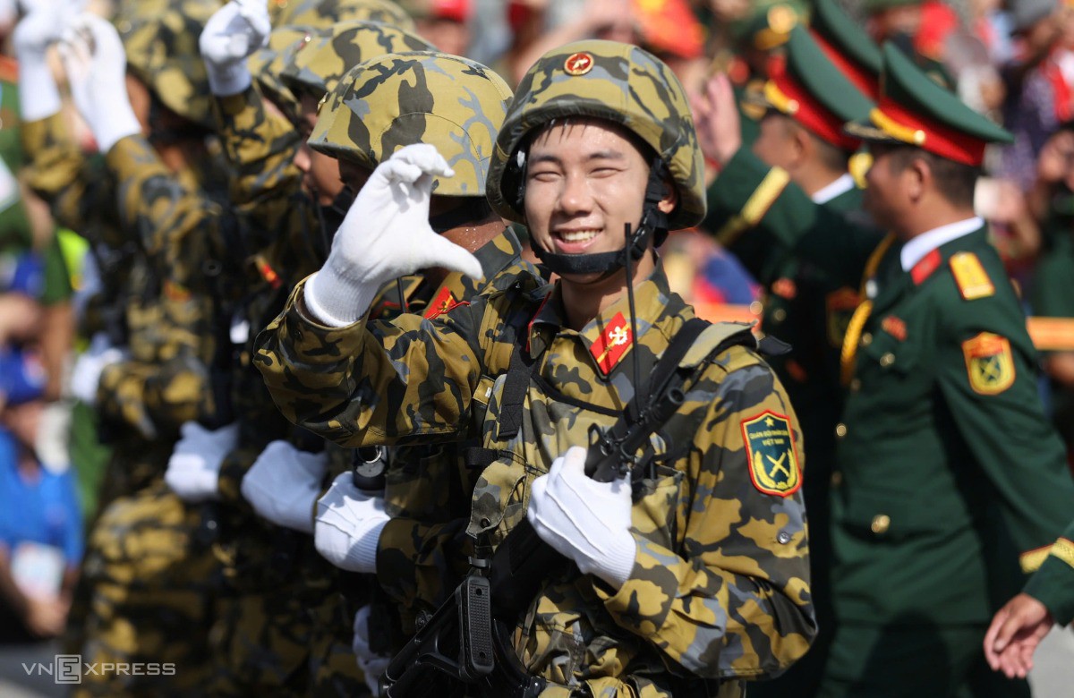 Chiến sĩ bộ đội phòng hóa bắn tim gửi người dân hai bên đường khi diễu binh qua Quảng trường Cách mạng tháng Tám. Ảnh: Đức Đồng
