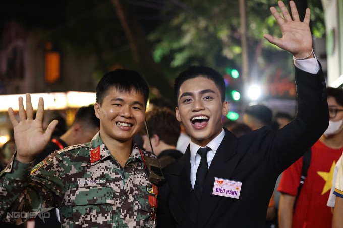 Hàng trăm ngàn người dân tập trung trên đường Quán Thánh phấn khích, reo hò không ngừng khi thấy dàn nghệ sĩ. MONO bắt tay, giao lưu các bạn trẻ hét tên mình. Trong ảnh, một chiến sĩ thuộc tổ an ninh cũng xin chụp ảnh cùng MONO.