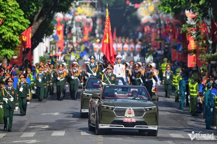 Thượng tướng Nguyễn Hồng Thái, Thứ trưởng Bộ Quốc phòng chào nhân dân ở hai bên đường. Ảnh: Nguyễn Huế