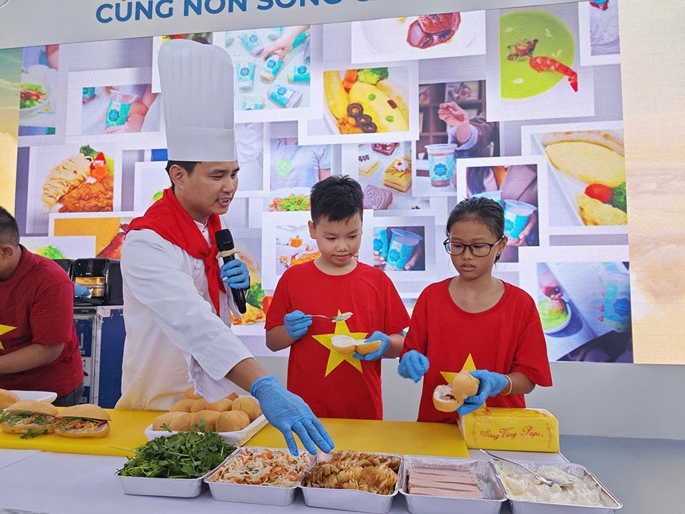 &nbsp;Em nhỏ say sưa tạo hình chiếc bánh mỳ đầu tiên của mình. (Ảnh: VNA).