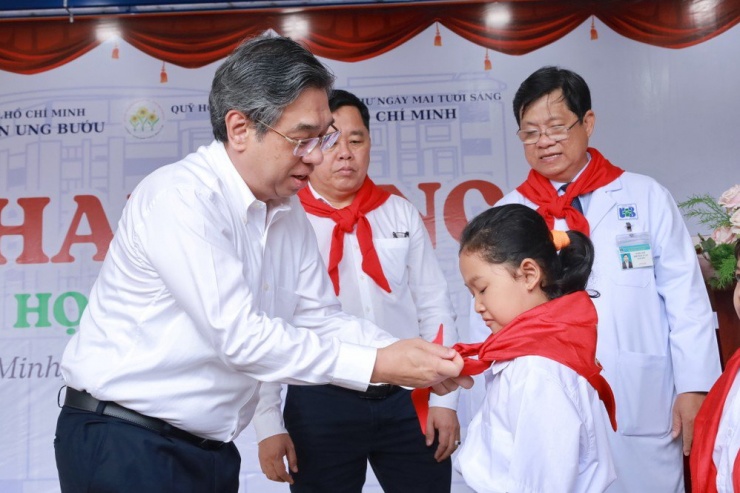 Ông Nguyễn Phước Lộc, Phó Bí thư Thành uỷ, Chủ tịch UBMTTQ Việt Nam TP.HCM thắt khăn quàng cho các bệnh nhi. Ảnh: DI LINH.